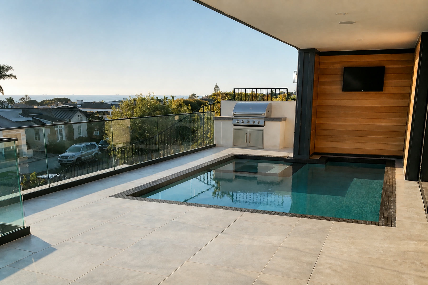 Elevated terrace pool with glass railing, built-in BBQ and ocean views in Corona del Mar, CA