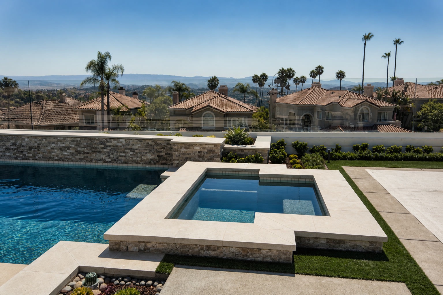 Raised spa with stone surround and panoramic views over rooftops to the mountains in Laguna Niguel, CA