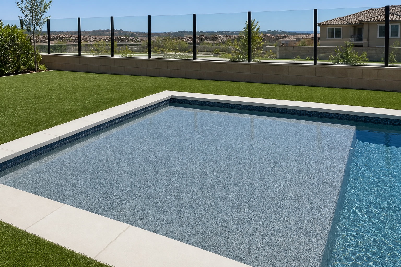 Baja shelf entry with tile waterline and turf lawn behind glass fencing in Portola Hills, CA