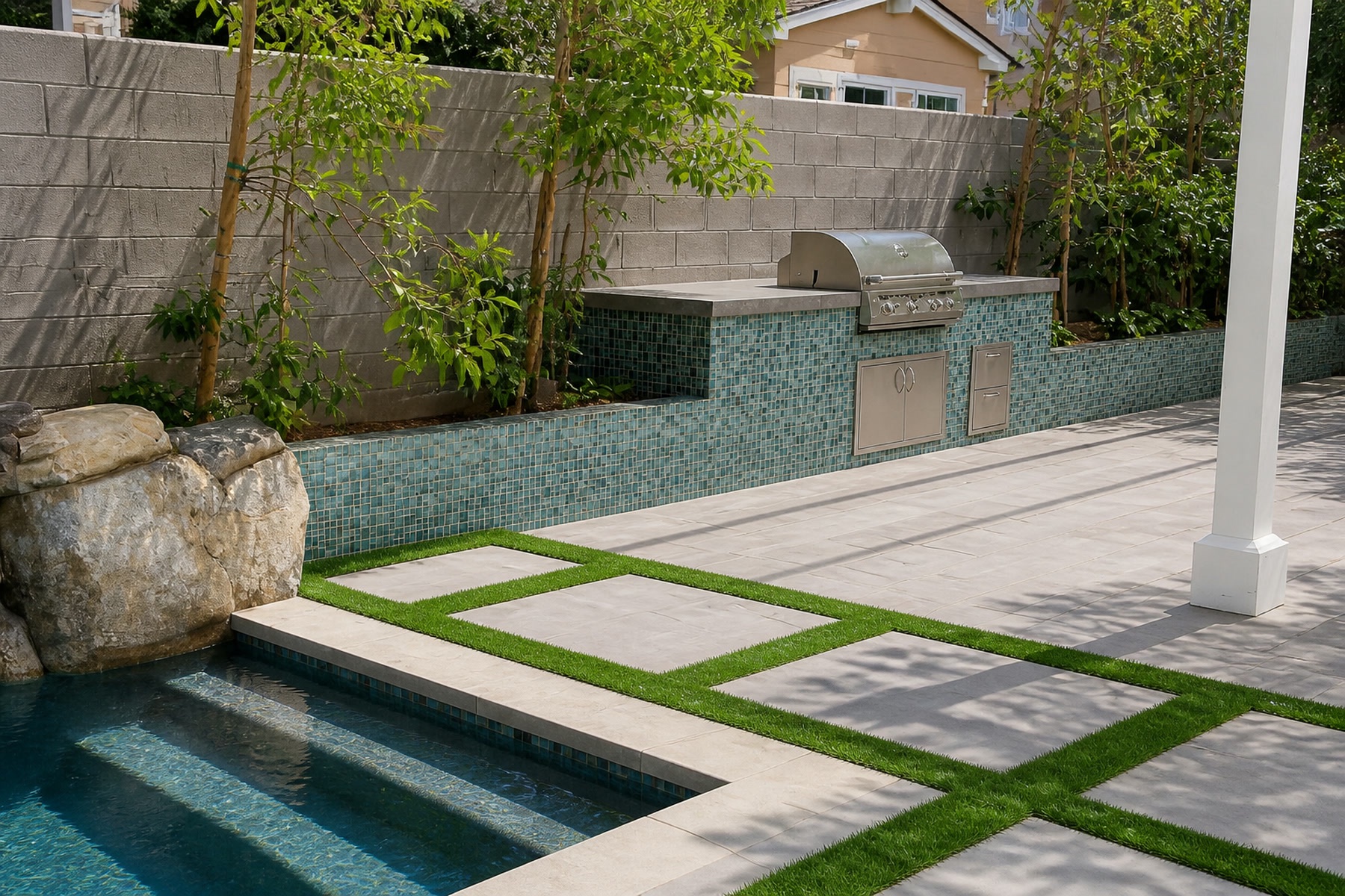 Built-in BBQ island clad in glass mosaic tile beside pool and paver deck in Rancho Mission Viejo, CA