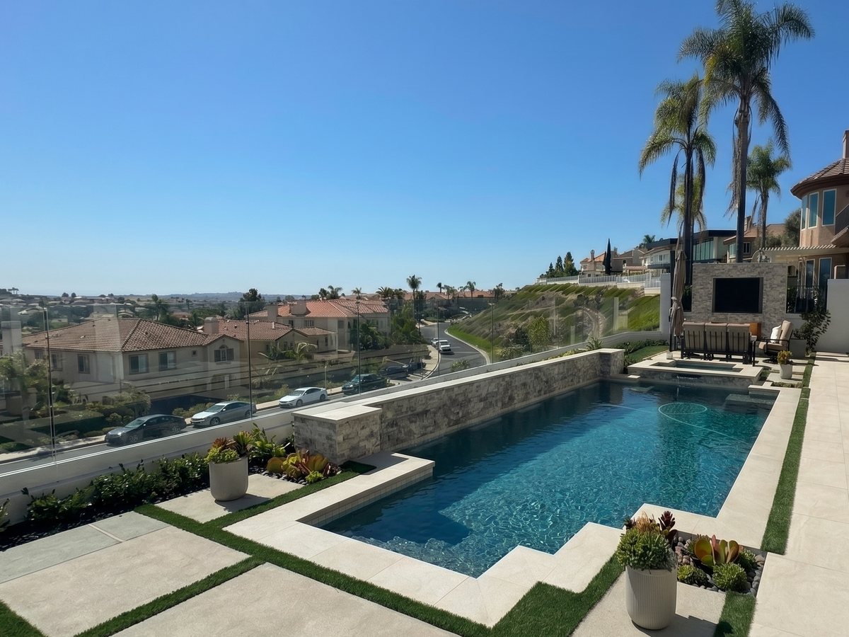 Custom hillside pool with raised wall, planters, and panoramic views